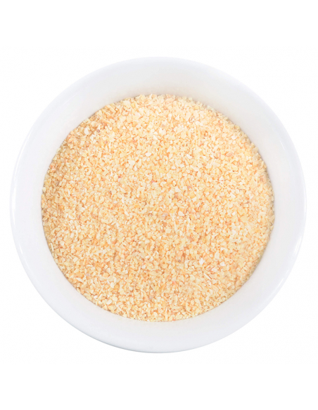 Weiße Schale mit fein-gelblich granuliertem Knoblauchpulver. Weiße Schale mit fein-gelblich granuliertem Knoblauchpulver.