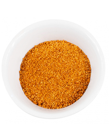 Weiße Schale gefüllt mit grobkörnigem, orangefarbenem Gewürzpulver.