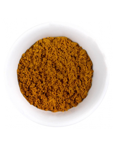 Dunkeloranges, grobkörniges Currypulver in weißer Schale, kompakt angehäuft.