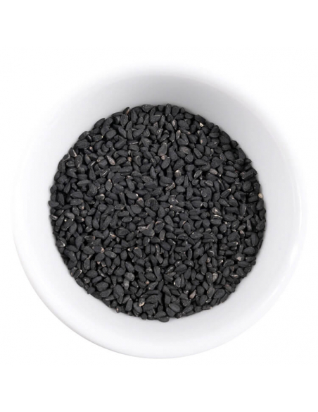 Weiße Schale mit kleinen, mattschwarzen Schwarzkümmelsamen. Weiße Schale mit kleinen, mattschwarzen Schwarzkümmelsamen.