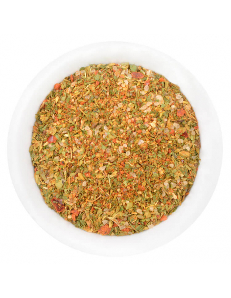 Weiße Schale mit einer fein gemahlenen Gewürzmischung, gleichmäßig vermischt mit kleinen Kräuter- und Gemüsestückchen.