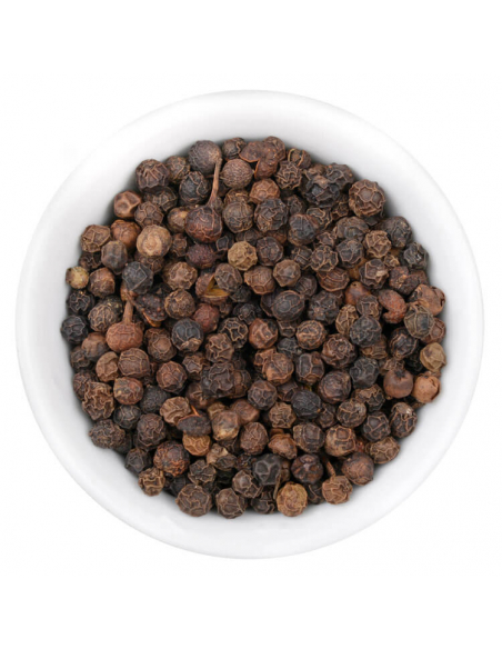 Ganze schwarze Pfefferkörner in weißer Schale, von oben fotografiert