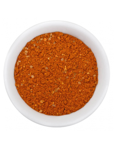 Rötlich-oranges Tandoori Masala Gewürzpulver mit kleinen Gewürzstückchen in weißer Schale, von oben fotografiert