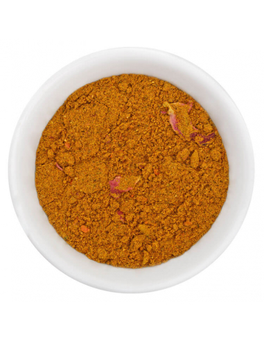 Fein gemahlenes braun-gelbes Ras el Hanout Gewürzpulver mit kleinen Stückchen in weißer Schale, von oben fotografiert