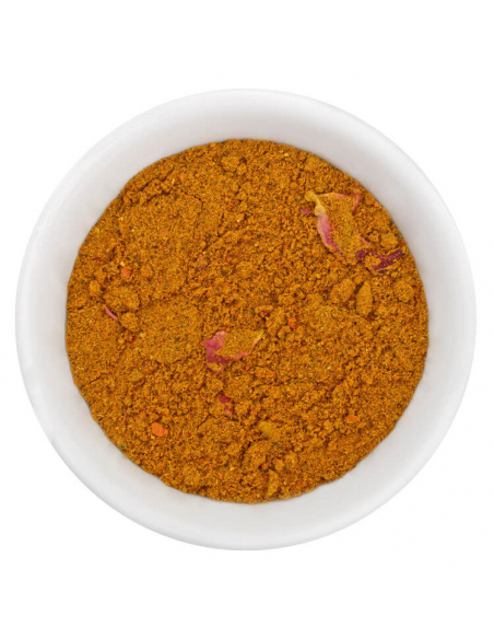 Fein gemahlenes braun-gelbes Ras el Hanout Gewürzpulver mit kleinen Stückchen in weißer Schale, von oben fotografiert Fein gemahlenes braun-gelbes Ras el Hanout Gewürzpulver mit kleinen Stückchen in weißer Schale, von oben fotografiert