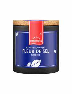 Pappdose mit blauem Etikett und Aufschrift „HANDGESCHÖPFTES FLEUR DE SEL NATUREL“.