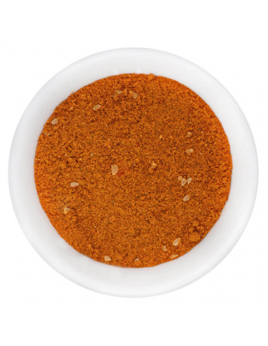 Fein gemahlenes rotes Thai-Currypulver mit Gewürzstückchen in weißer Schale, von oben fotografiert