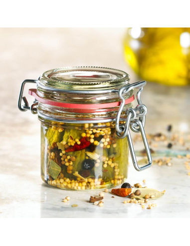 Rundes Einmachglas mit eingelegten Gewürzen, darunter Senfkörner, Lorbeer und Pfefferkörner.