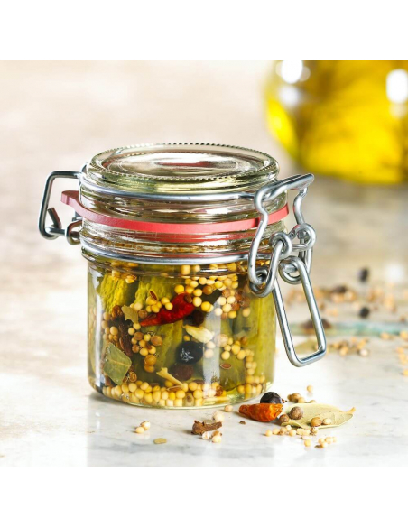 Rundes Einmachglas mit eingelegten Gewürzen, darunter Senfkörner, Lorbeer und Pfefferkörner.
