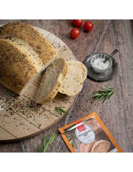 Mediterran gewürztes Brotleib auf einem Holzbrett, daneben frische Kräuter und Tomaten. Mediterran gewürztes Brotleib auf einem Holzbrett, daneben frische Kräuter und Tomaten.