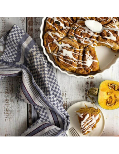 Kuchen mit Zuckerguss in runder Form, angeschnitten mit Serviette daneben