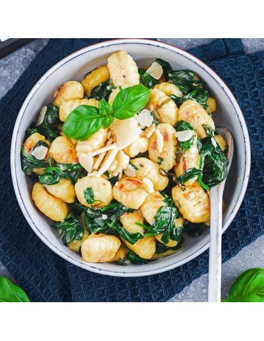 Teller mit Gnocchi, Spinat, Basilikum und Parmesanspänen