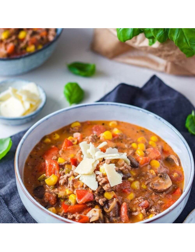 Schale mit Hackfleisch-Gemüse-Eintopf, Mais, Käse und Basilikum