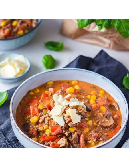 Schale mit Hackfleisch-Gemüse-Eintopf, Mais, Käse und Basilikum