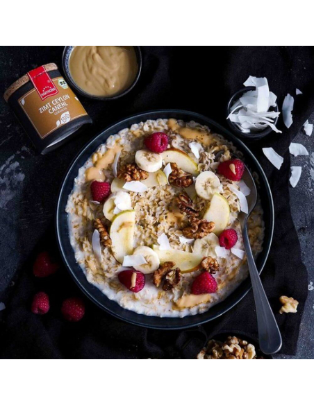 Schale mit Porridge, Apfelscheiben, Walnüssen, Himbeeren und Kokoschips Schale mit Porridge, Apfelscheiben, Walnüssen, Himbeeren und Kokoschips