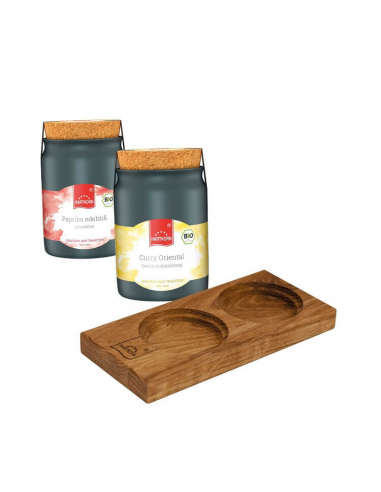 Zwei schwarze Keramiktöpfchen mit den Etiketten „Paprika edelsüß“ (rot) und „Curry Oriental“ (gelb), daneben Holztablett