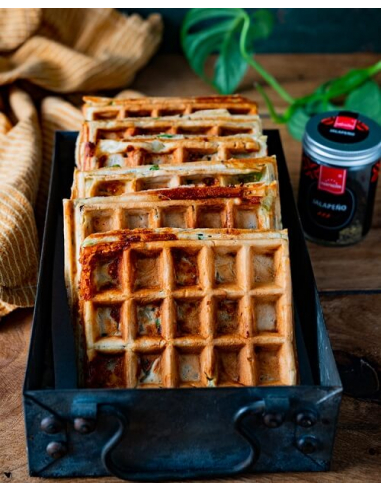 Jalapeño-Käse Waffeln - Herzhafte Waffeln mit Jalapeño in schwarzer Backform, im Hintergrund Glas mit Hartkorn-Logo