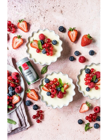 Ansicht mit kleinen Dessertschälchen, Beeren und Sahnecreme. Im Bild ist  eine geöffnete Tonkabohnendose zu sehen.