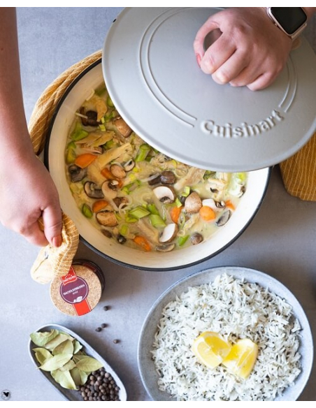 Topf mit Gemüseeintopf, daneben Schale mit Reis, Butterflocken und Gewürzen