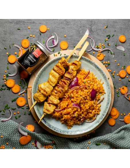 Tandoori-Hähnchenspieße mit Linsen, roten Zwiebeln und Karottenscheiben auf Teller, daneben Tandoori Masala