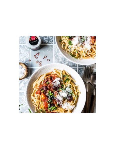 Spaghetti mit Tomatensoße, Oliven und Hartkorn Chiliringe, garniert mit Petersilie und Parmesan - Pasta alla Puttanesca