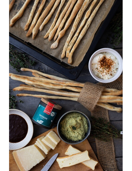 Servierbrett mit Käse, Dips, Brotstangen und Dose Thymian Servierbrett mit Käse, Dips, Brotstangen und Dose Thymian