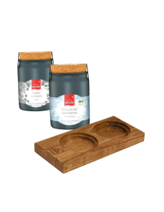 Zwei schwarze Keramiktöpfchen mit Etiketten „Fleur de Sel mediterran“ und „Pfeffer schwarz“ neben rechteckigen Servierholzbrett