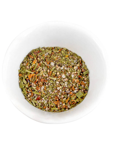 Bunte Kräuter-Gewürzmischung mit getrockneten Stücken in einer weißen Schale.