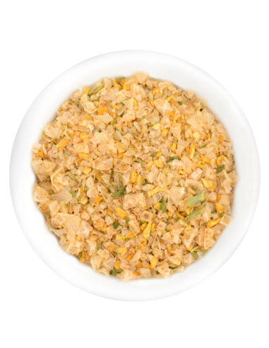 Grobe, beige-orange Mischung mit getrockneten Kräutern und Gemüsestückchen in weißer Schale