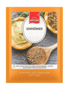 Flachbeutel mit Senfkörnern vor einer Schale Senf und Holzlöffel mit Körnern