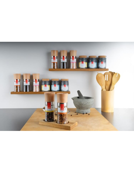 Im Hintergrund mehrere Mühlen und Töpfchen auf Wandregalen in einer modernen Küche.