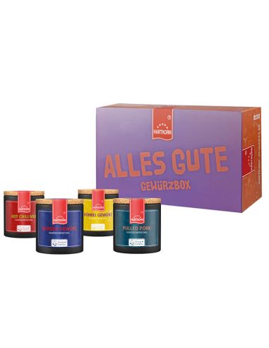 Violett-orangefarbene Box mit der Aufschrift „Alles Gute Gewürzbox“, davor vier farbige Pappdosen mit Gewürzen.