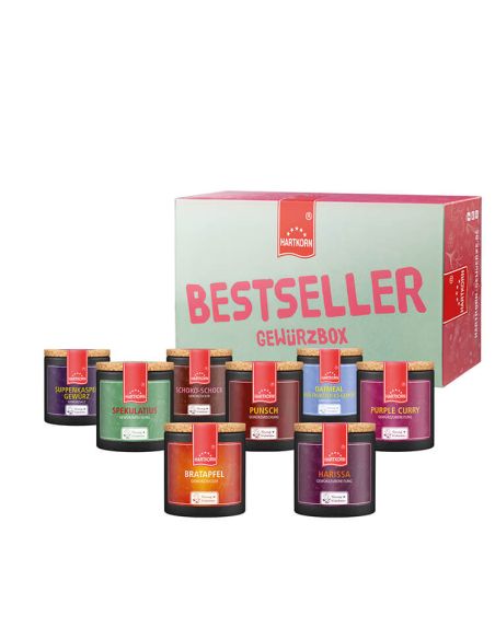 Geschenkbox mit der Aufschrift „Bestseller Gewürzbox“. Davor bunte Pappdosen mit Korkdeckel, die verschiedene Gewürze enthalten.