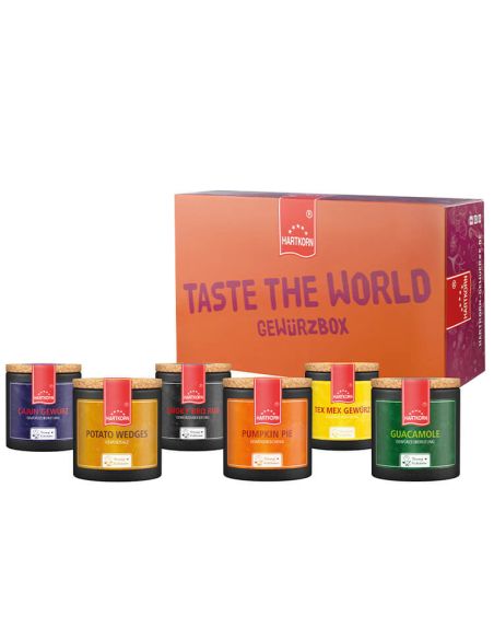 Box mit der Aufschrift ‚Taste the World Gewürzbox‘ neben sechs schwarzen Pappdosen mit verschiedenfarbigen Etiketten.“