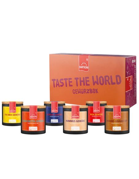 Box mit der Aufschrift „Taste the World Gewürzbox“, davor neun Pappdose in kräftigen Farben.