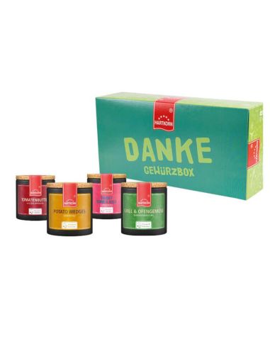 Geschenkbox mit der Aufschrift „Bestseller Gewürzbox“. Davor bunte Pappdosen mit Korkdeckel, die vier Gewürze enthalten.