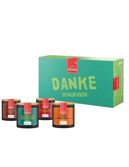 Grüne Geschenkbox mit rotem Etikett, der Schriftzug „DANKE GEWÜRZE“, davor stehen vier Pappdosen in verschiedenen Farben.