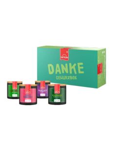 Grüne Geschenkbox mit rotem Etikett, der Schriftzug „DANKE GEWÜRZE“, davor stehen vier Pappdosen in verschiedenen Farben.
