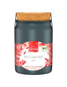 Schwarzes Keramiktöpfchen mit Korkdeckel, Etikett mit rotem Chili-Design und der Aufschrift „Bird’s Eye Chili ganz“.