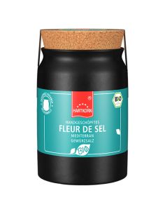 Schwarzes Keramiktöpfchen mit türkisfarbenem Etikett und Korkdeckel, Aufschrift „Fleur de Sel mediterran“.