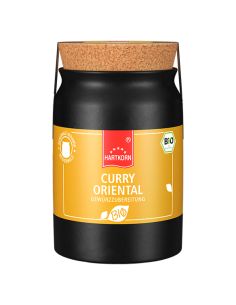 Schwarzes Keramiktöpfchen mit gelbem Etikett, Korkdeckel und der Aufschrift „Curry Oriental Gewürzzubereitung“