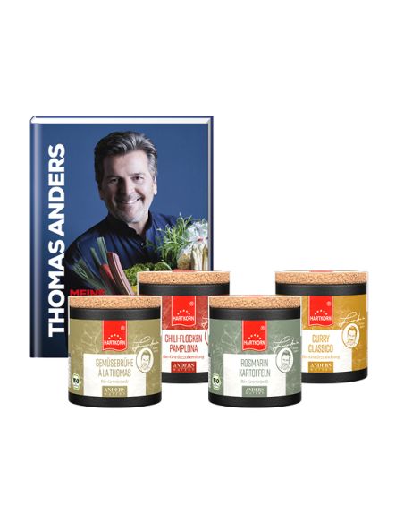 Kochbuch von Thomas Anders mit seinem Porträt auf dem Cover. Davor stehen vier farblich abgestimmte Pappdosen mit Korkdeckel.