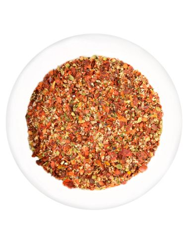 Weiße Schale mit grob geschroteten, rot-gelben Chili und Knoblauch.