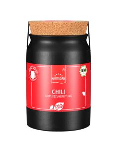 Schwarzes Keramiktöpfchen mit rotem Etikett und der Aufschrift „Chili Gewürzzubereitung“.