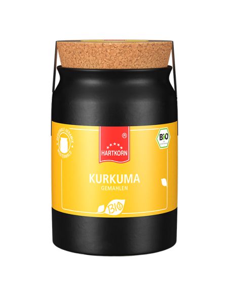 Schwarzer Keramiktopf mit gelbem Etikett und Korkverschluss, beschriftet mit „Kurkuma“. Schwarzer Keramiktopf mit gelbem Etikett und Korkverschluss, beschriftet mit „Kurkuma“.