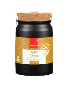 Schwarzes Keramiktöpfchen mit Korkdeckel. Gelbes Etikett mit rotem Band: Curry Classico Gewürzzubereitung‘. BIO-Siegel sichtbar.