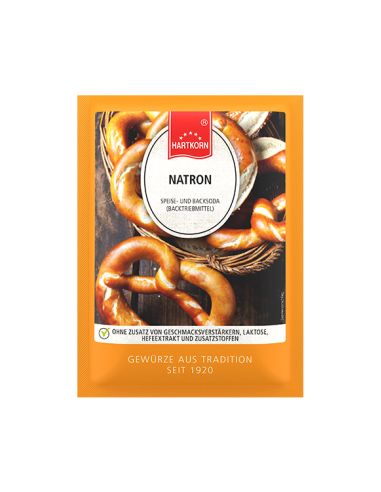 Flachbeutel mit der Aufschrift „Natron“ vor einem Glas mit Zitronenwasser und Beeren.