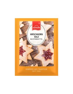 Flachbeutel mit der Aufschrift „Hirschhornsalz“, dahinter helle Sternplätzchen mit roter Füllung.