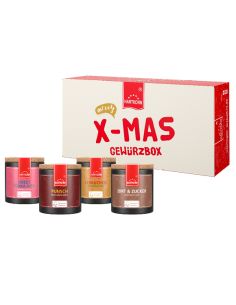 Geschenkbox mit der Aufschrift „X-MAS Gewürzbox“. Davor bunte Pappdosen mit Korkdeckel, die verschiedene Gewürze enthalten.