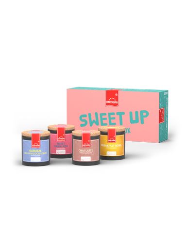 Box mit der Aufschrift „Sweet Up Gewürzbox“, davor vier farbenfrohe Pappdosen mit unterschiedlichen Etiketten.